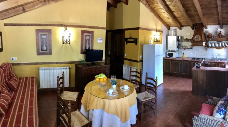 Salón rústico con vigas de madera y chimenea de leña