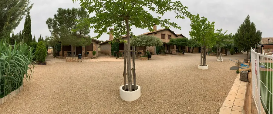 Vista panorámica del complejo de Cabañas El Acuífero, con las casas de piedra repartidas alrededor del patio central de grava