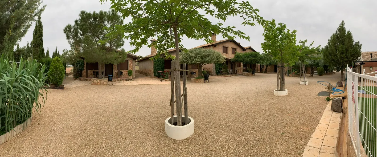 Vista panorámica del complejo de Cabañas El Acuífero, con las casas de piedra repartidas alrededor del patio central de grava